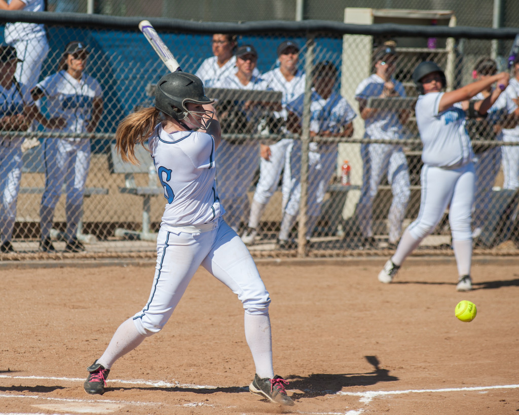 softball player hitting a ground ball