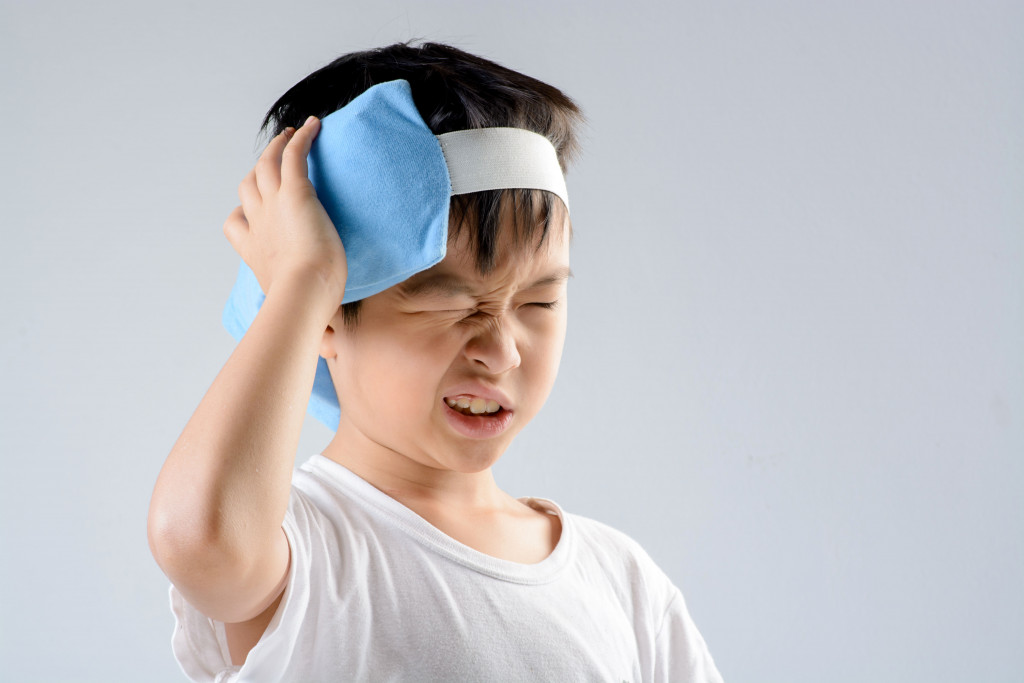 kid with ice pack covered in linen being used for his concussion