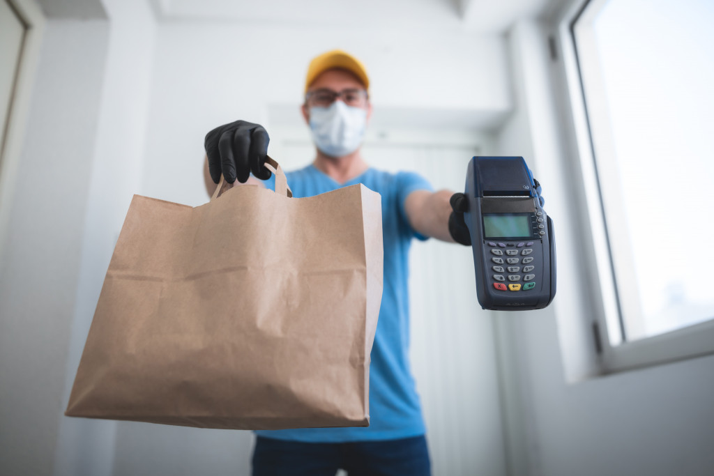 A man processesing a contactless delivery transaction