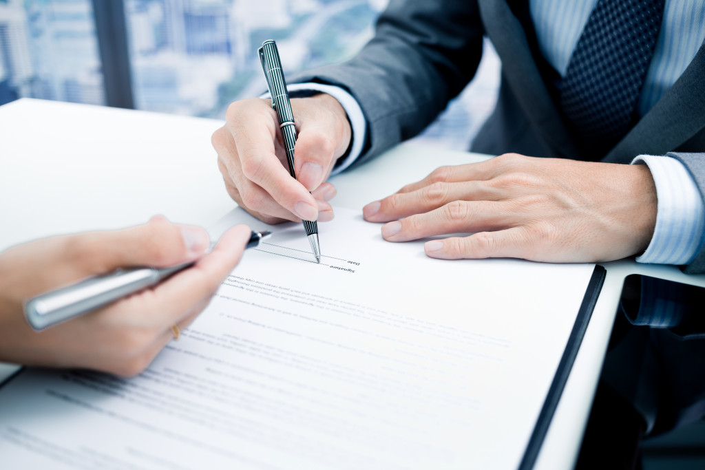 Two businessmen signing a contract policy