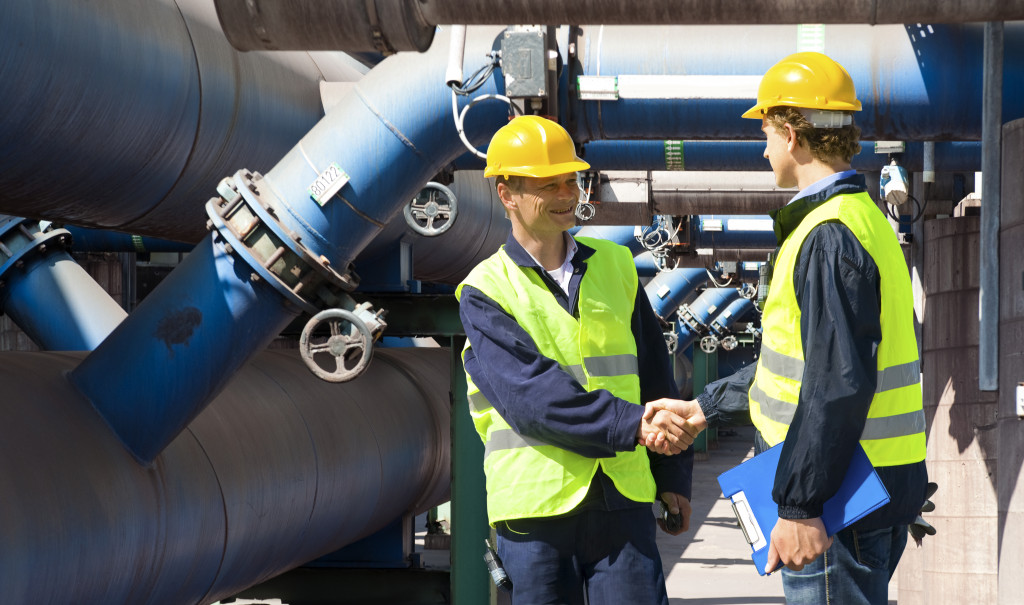 two men shaking hands outside a plant for waste management