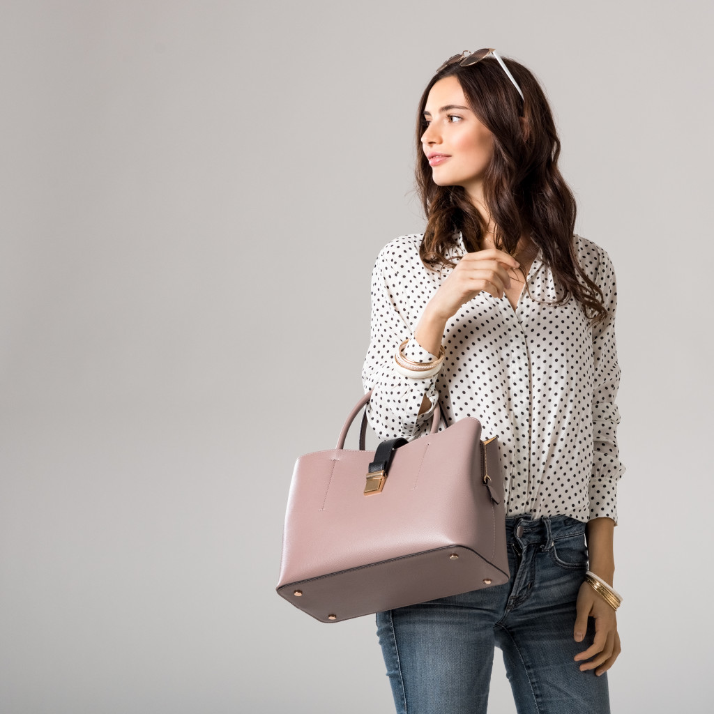 woman with polka dot top and pink bag